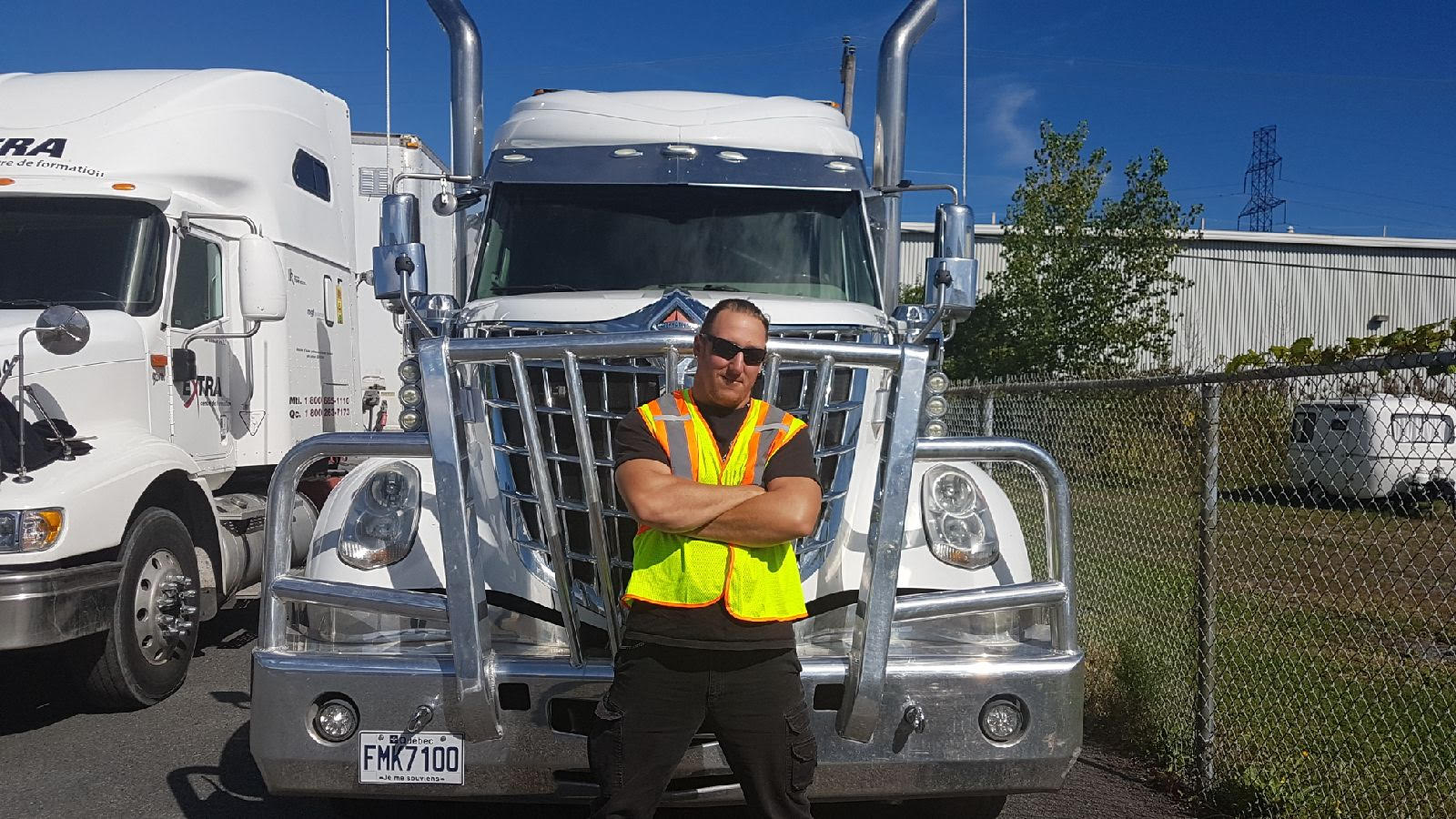 Sébastien Major Mainville avec des lunettes de soleil devant un camion de transport