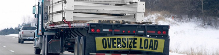 Panneau écrit oversize load derrière un camion sur la route